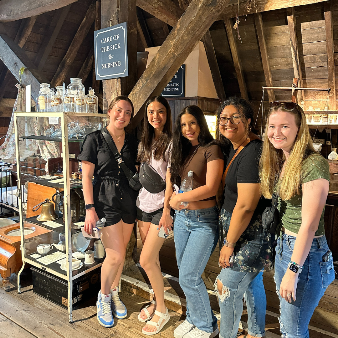 Edson College nursing students pose next to a nursing display at the Old Operating Theatre and Museum in London