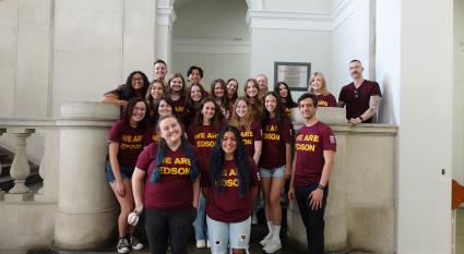 Edson College study abroad students pose for a photo at King's College London. They are all wearing maroon short sleeve shirts with the text, We Are Edson, across the front.