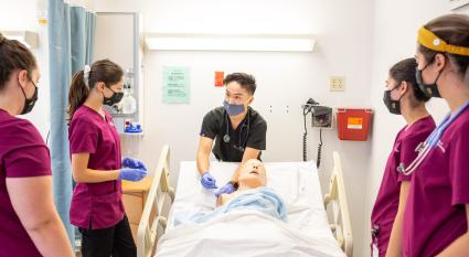 Edson College Faculty Associate Joseph Tran demonstrates where to inject on a manikin to nursing students.