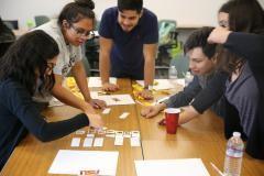 A group of students around a table working on a project together