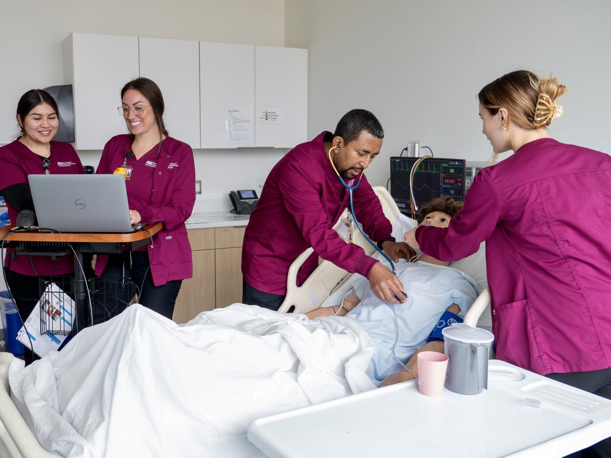 Nursing students work with a simulation mannequin