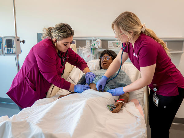 Nursing students working with simulation mannequin