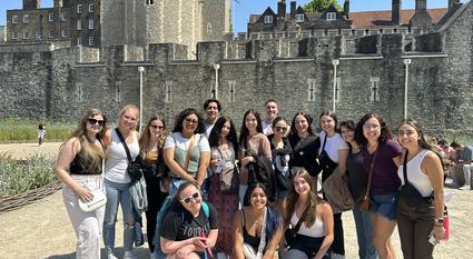 ASU students throw the pitchfork while standing in front of the Tower of London.